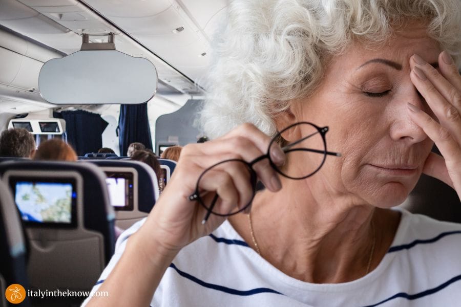 Cabin inside a plane with a woman with a headache