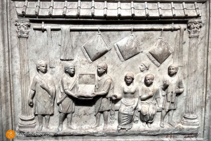 Stone relief of an ancient Roman shop selling pillows to customers