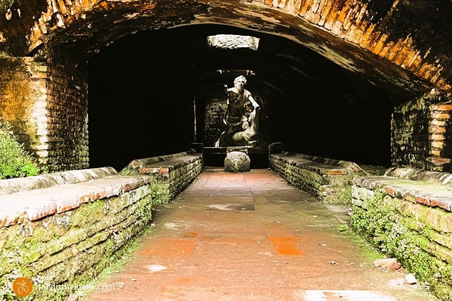 Mithraeum with a central aisle,bench seating on both sides, and a statue of Mithras and a bull in the center at the end of the aisle