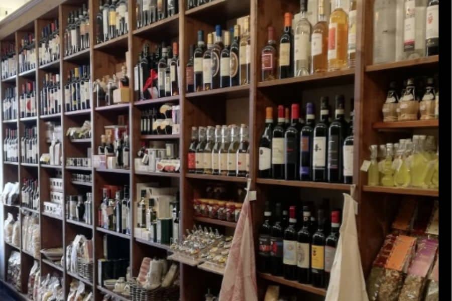 Shop interior with shelves of wine, olive oil, and other goods.