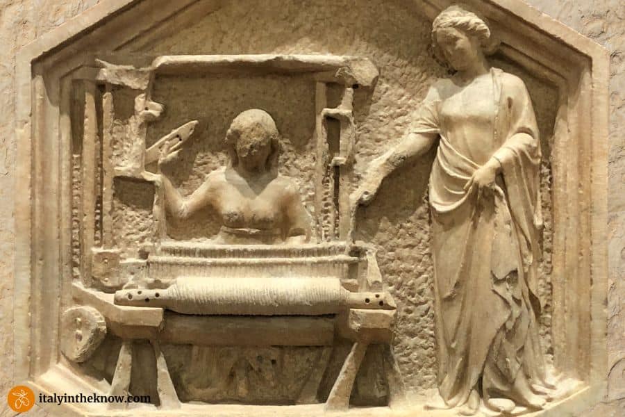 Medieval stone relief of two women with a loom