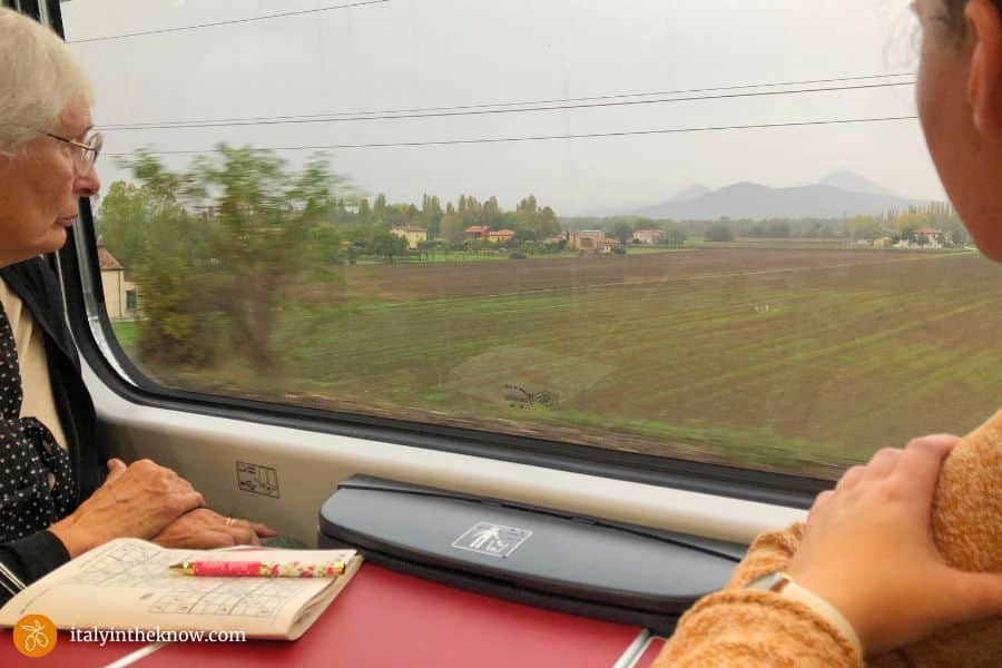 two women looking out a train window at the Italian countryside